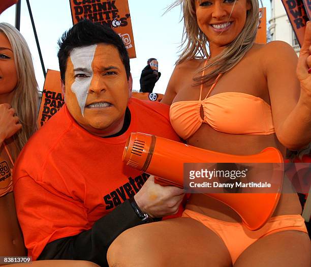 Dom Joly Promotes 'Tango' in a cart pulled by a Shetland pony, flanked by body painted orange page 3 models, and orange "umpa lumpas" by London...