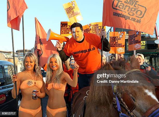 Dom Joly Promotes 'Tango' in a cart pulled by a Shetland pony, flanked by body painted orange page 3 models, and orange "umpa lumpas" by London...