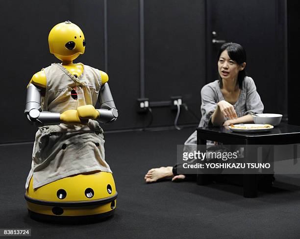 Humanoid robot Wakamaru , produced by Japan's Mitsubishi Heavy Industry, and named Momoko in the performance and actress Minako Inoue take part in a...
