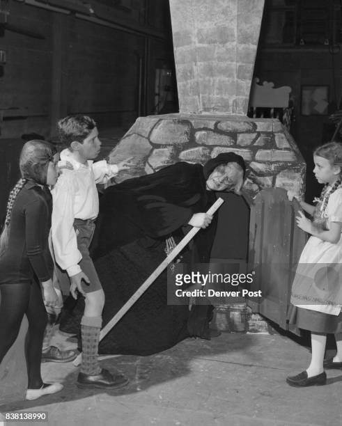 Three children imprisoned by the evil witch in Madge Miller's adaptation of "Hansel and Gretel" line up the sorceress for a quick push into the oven....