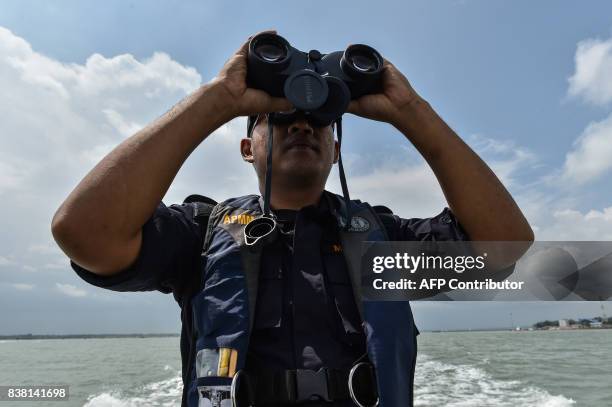 Member of the Malaysian Maritime Enforcement Agency officer uses a pair of binoculars to scan the sea during the rescue operation for the missing...