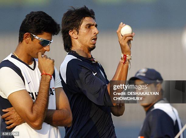 Indian cricketer Ishant Sharma prepares to deliver a ball watched by fielding coach Robin Singh and bowling coach Venkatesh Prasad during a net...