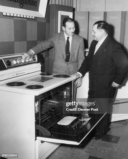 Roseberry , assistant sales manager for McCollum-, Law Corp., shows Sam Smith, Laramie, Wyo., appliance dealer, the 1955 Westinghouse electric range...