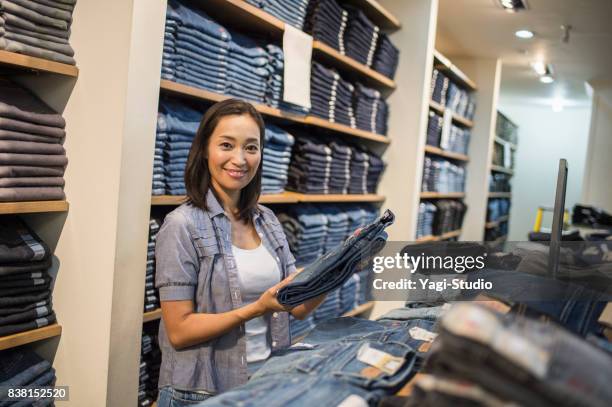 mid adult woman choosing clothes - guam premier outlets stock pictures, royalty-free photos & images