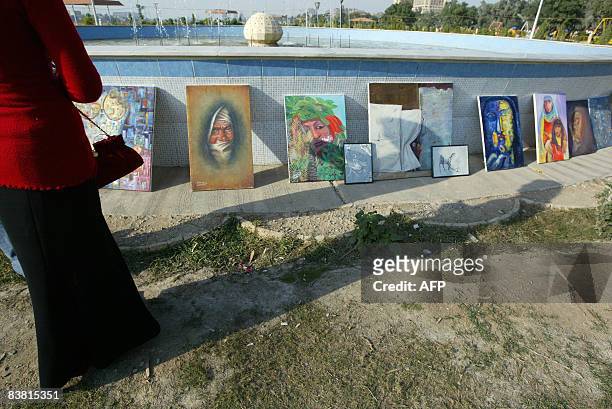 Painting are put on display as Iraqi women gather in a park along the Tigris River in central Baghdad to mark the International Day for the...