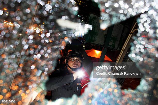 Thai policeman inspect the broken glass at Vibhavadi Road on November 25, in Bangkok, Thailand. Eleven people were injured when the anti-government...