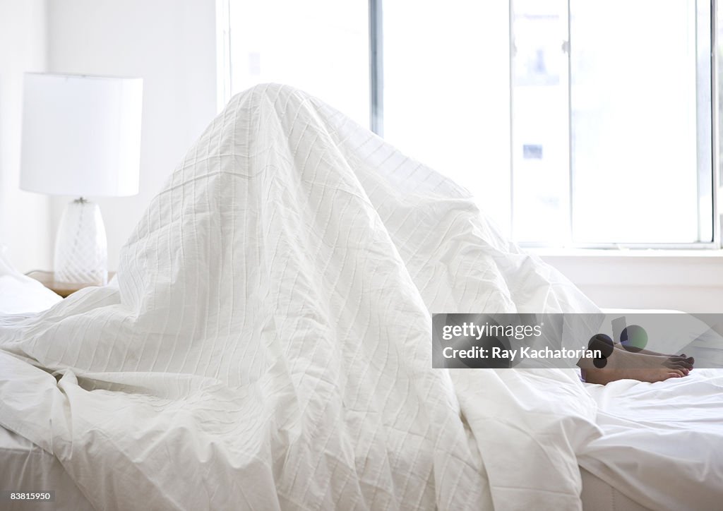 Sitting in bed sheets over head horizontal