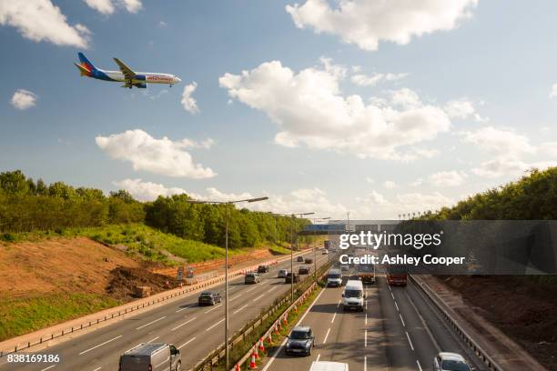 tailbacks on the m1 motorway in the east midlands caused by roadworks with a plane coming in to land at east midlands airport, uk. - motorvägen m1 bildbanksfoton och bilder