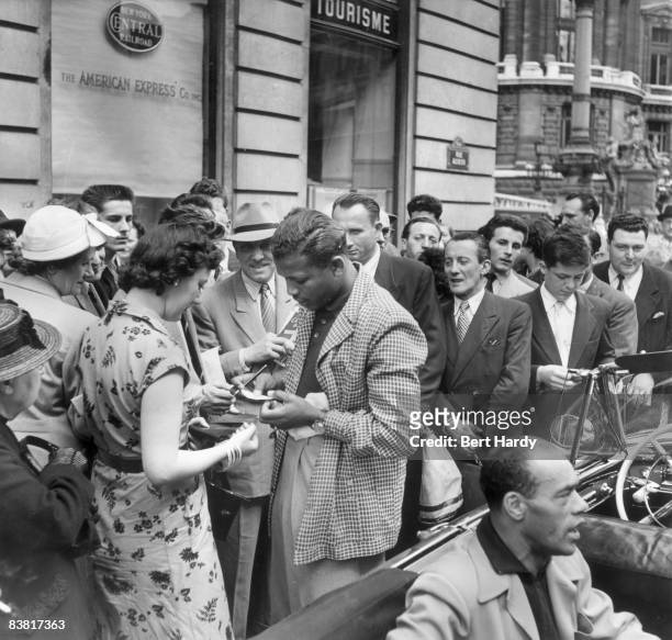 American world middle and welterweight boxing champion Sugar Ray Robinson signing autographs in Paris before his world middleweight fight against...