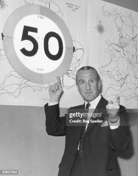 British Minister of Transport Ernest Marples points to a 50 mph speed limit sign at St Christopher house, London, 25th May 1963. Marples has just...