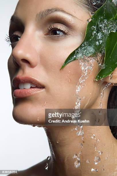 woman with water running down face, profile. - face down stock-fotos und bilder