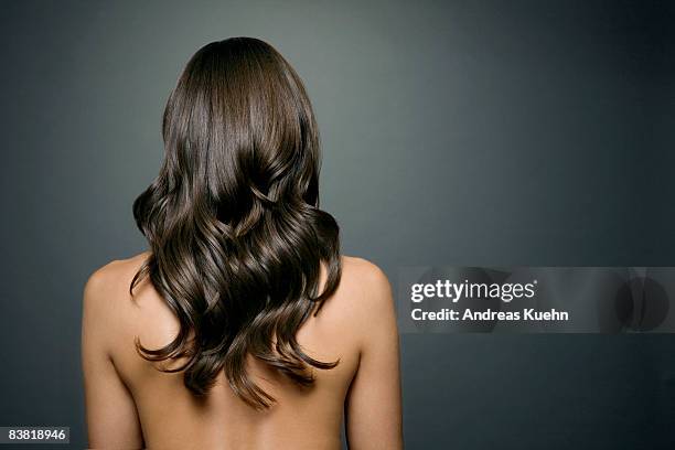 naked woman with long shiny wavy hair, back view. - brunette woman back stockfoto's en -beelden