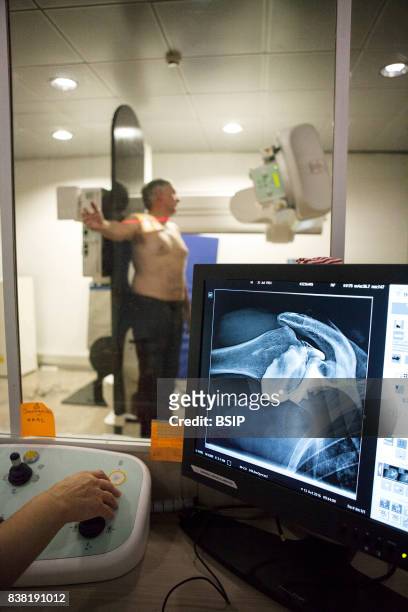 Radiology center, France, technician carries out an arthography of the shoulder with osteoarthritis.