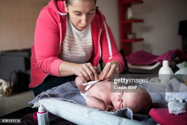 Reportage on an independent midwife during post-partum home visits. The midwife cleans the umbilical cord.