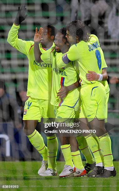 Lyon's Camerounese midfielder Jean II Makoun celebrates with teammates Brazilian midfielder Pernambucano Juninho and forward Sidney Govou after...