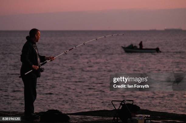 Fisherman stands on the end of the breakwater at South Gare on August 24, 2017 in Redcar, England. The manmade breakwater at South Gare helps protect...