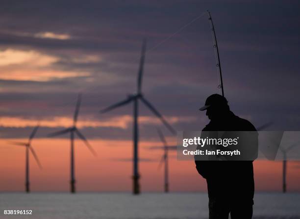 Fisherman stands on the end of the breakwater as he fishes at South Gare on August 24, 2017 in Redcar, England. The manmade breakwater at South Gare...