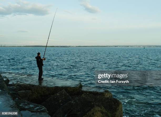 Fisherman stands on the end of the breakwater as he fishes at South Gare on August 24, 2017 in Redcar, England. The manmade breakwater at South Gare...