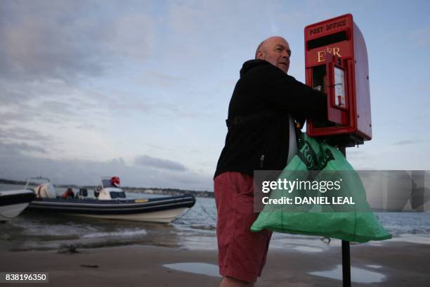 Arthur Reeder from the Isle of Wight Postal Museum sets up a temporary postbox on the Brambles Bank ahead of an annual cricket match contested...