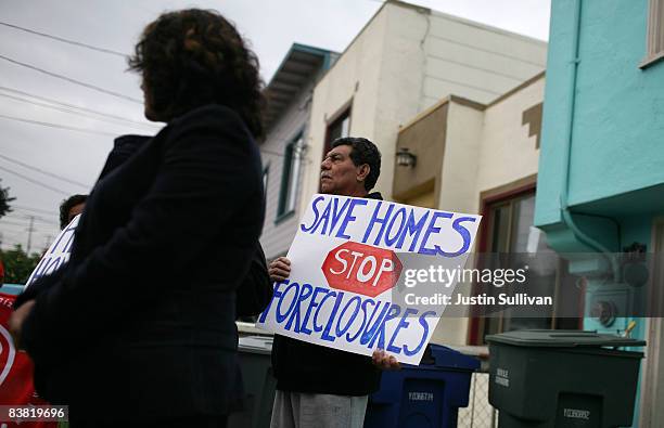 Roberto Colocho holds a sign during a press conference about home foreclosures November 25, 2008 in South San Francisco, California. Community...