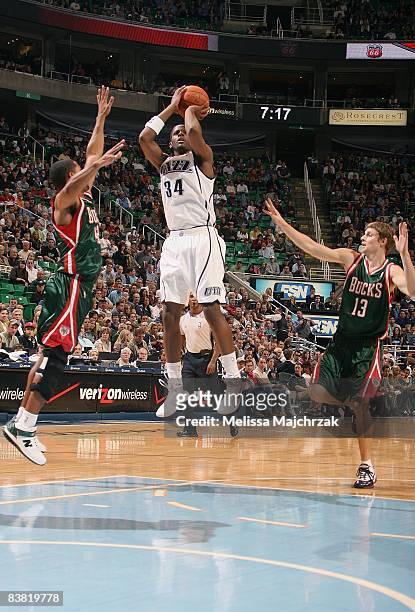 Miles of the Utah Jazz shoots a jumper between Charlie Bell and Luke Ridnour of the Milwaukee Bucks during the game on November 19, 2008 at...