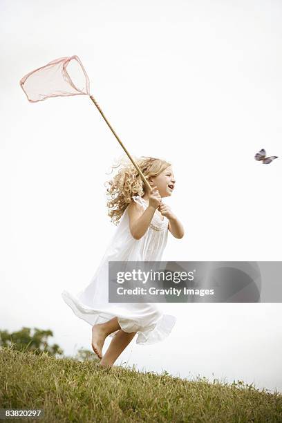 young girl chasing butterflies - butterfly net stock pictures, royalty-free photos & images