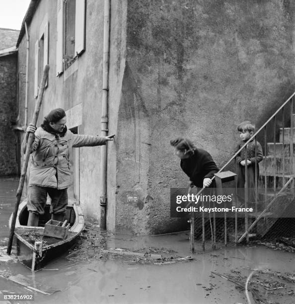 Dans les rues inondées, la population doit circuler sur des barques, en France en 1955.