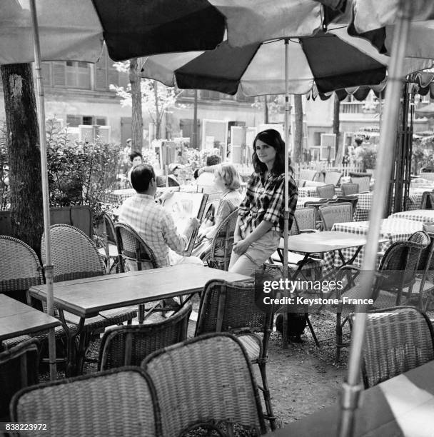 Un peintre dessine le portrait d'une femme à la terrasse d'un café Place du Tertre à Paris, France le 30 juillet 1961.