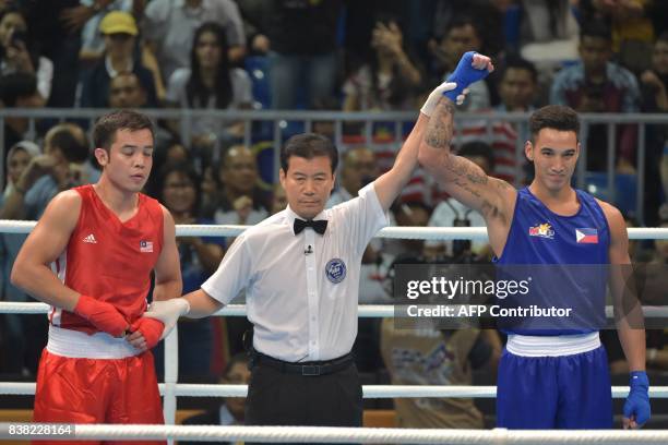 The referee holds Marvin John Nobel Tupas' hand of the Philippines after fighting against Adli Hafidz binti Mohamad Fauzi of Malaysia during the...