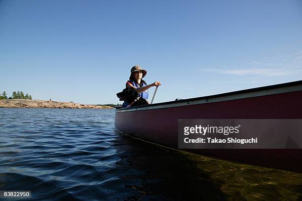 woman paddling a canoe - parry sound stock pictures, royalty-free photos & images