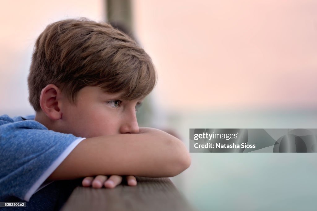 Young boy gazing out into the sunset