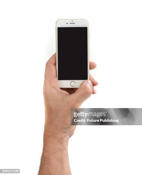Hand holding an Apple iPhone 6 smartphone with a Gold finish, taken on April 29, 2015.