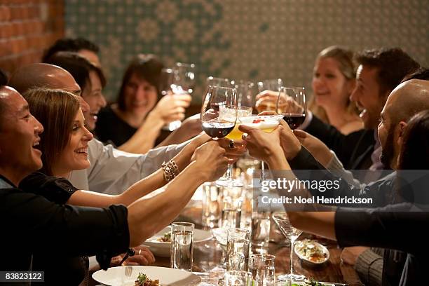 people raising glasses at restaurant - black tie dinner stock pictures, royalty-free photos & images