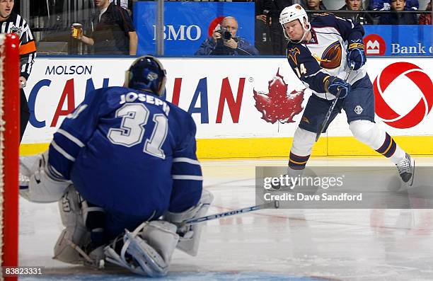 Curtis Joseph of the Toronto Maple Leafs makes a save on Jason Williams of the Atlanta Thrashers during their NHL game at the Air Canada Centre...