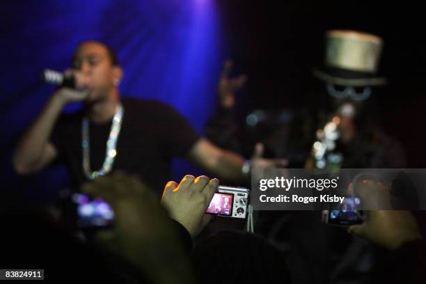 Fans take photos as rapper Chris "Ludacris" Bridges and singer T-Pain perform onstage to promote Ludacris' new album "Theater of the Mind" at the...