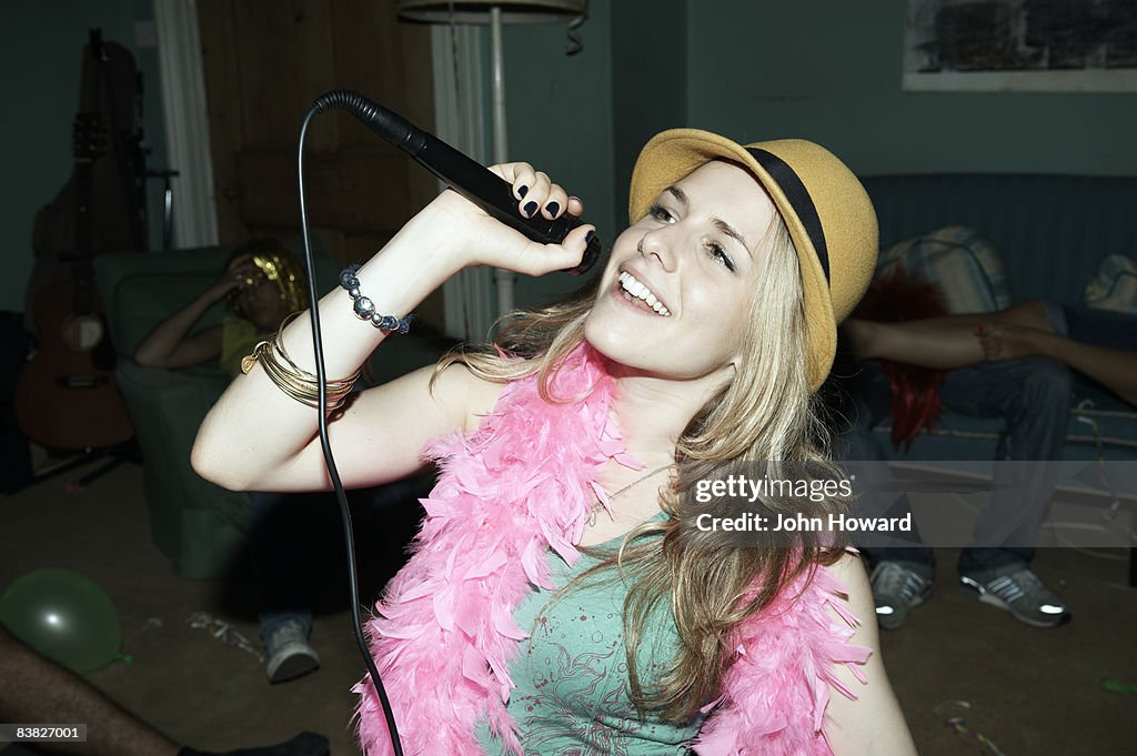 Frau singen karaoke in der house-party