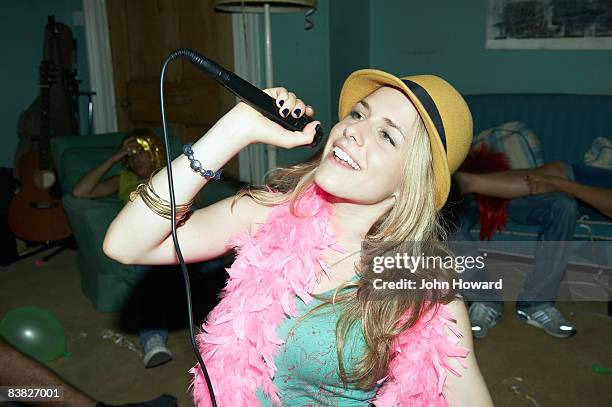 frau singen karaoke in der house-party - karaoke anlage stock-fotos und bilder