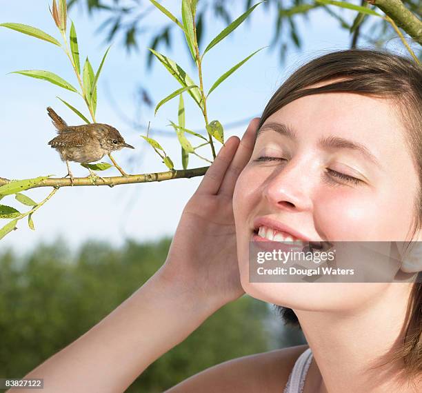 young woman listening to small bird. - birdsong 個照片及圖片檔