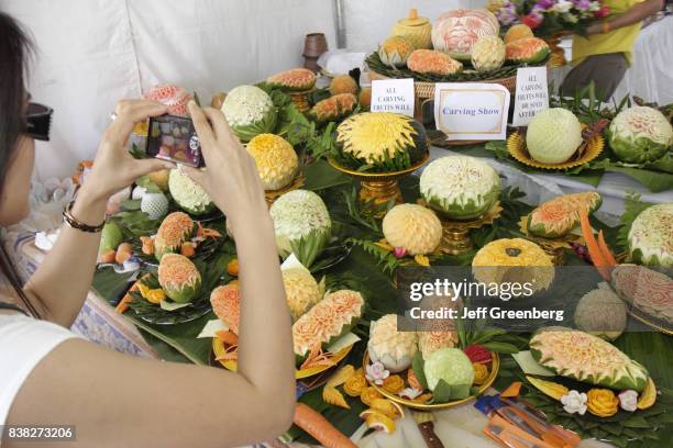 Woman taking a picture of Thailand fruit carving at the Asian Culture Festival at Fruit and Spice Park.
