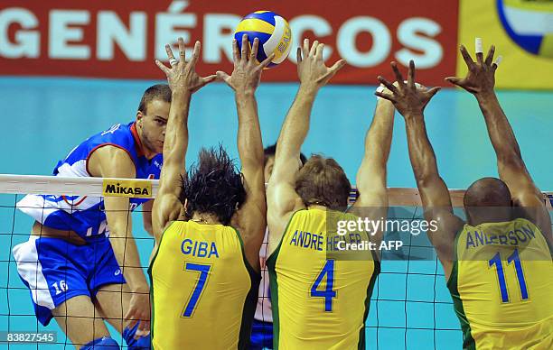 Brazil's Giba, Andre Heller and Anderson jump to block France's Ragondet's spike during their Volleyball World League fifth round match in Belo...