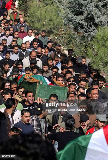 Mourners attend the funeral of a 53-year-old Palestinian woman who died of a heart attack after Israeli soldiers came to her house overnight to...