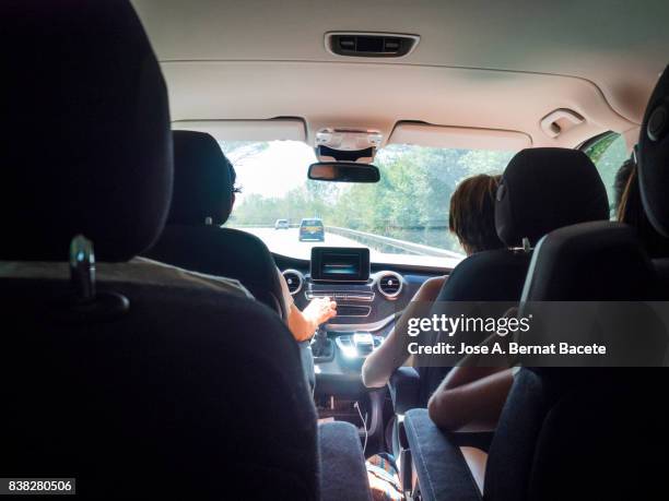 family in the interior of a vehicle circulating along a highway with the help of a gps one day with traffic and the sun. catalonia, spain - family car at home stock-fotos und bilder