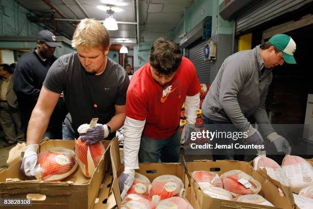 Giants Adam Koets, Chris Snee and David Diehl load trucks with turkeys for Thanksgiving dinner for the Food Bank Community Kitchen of West Harlem at...