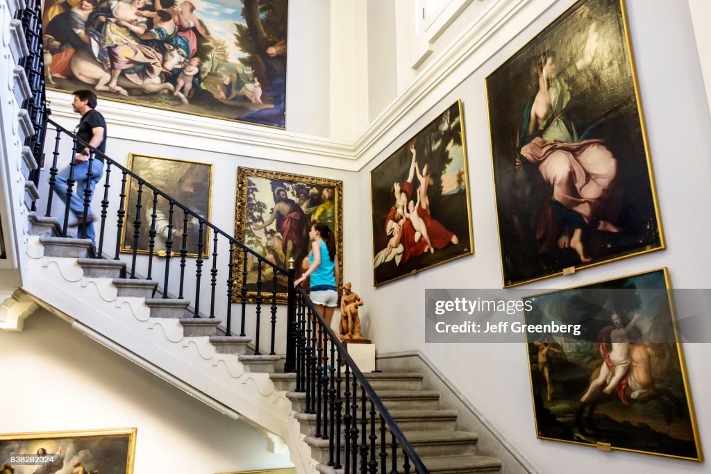 A stairway of paintings inside the Royal Academy of Fine Arts.