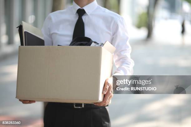 close-up of unemployed businessperson carrying cardboard box - downsizing unemployment stock-fotos und bilder