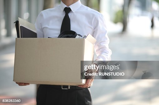 Close-up Of Unemployed Businessperson Carrying Cardboard Box Close-up Of Unemployed Businessperson Carrying Cardboard Box