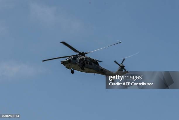 Navy helicopter MH-60S Knighthawk flies over the rescue operation area for the missing sailors from the USS John S. McCain off the Johor coast of...