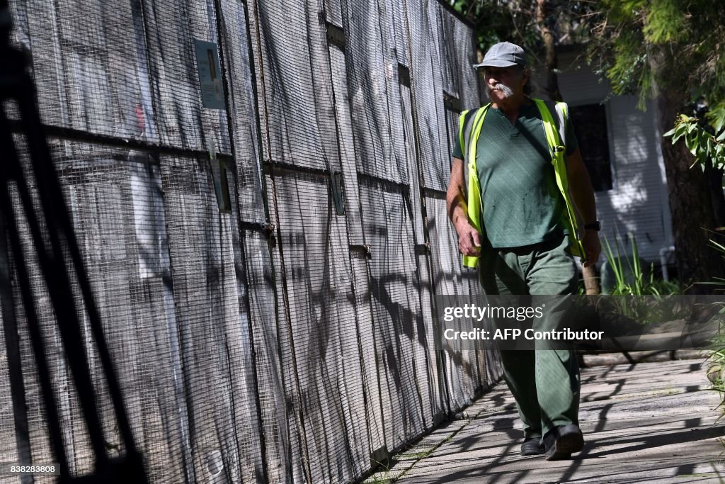 Animal In Jail An inmate walks next to birds cages to look after animals at John ...