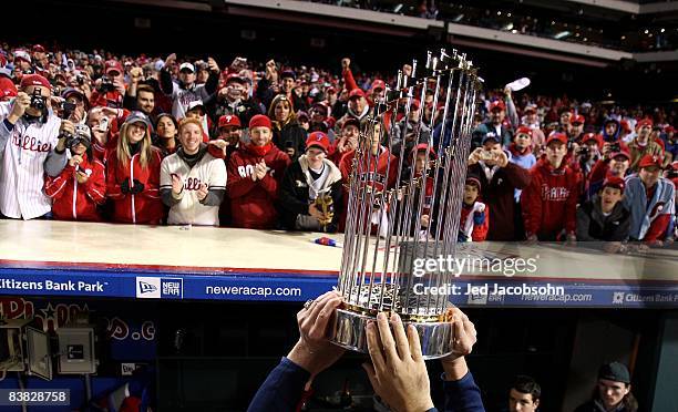 The World Series Championship trophy is held up in front of fans of the Philadelphia Phillies after they won 4-3 against the Tampa Bay Rays during...