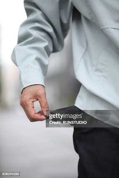 closeup of a business man pulling out empty pocket - empty pockets stock pictures, royalty-free photos & images